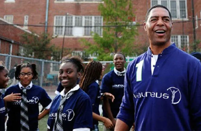 A team of students stands with their coach wearing matching sport jerseys.