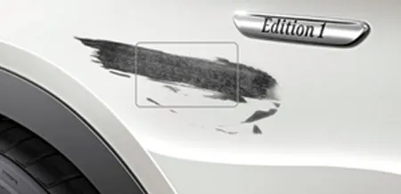 A close-up of a scratch on the fender of a vehicle.