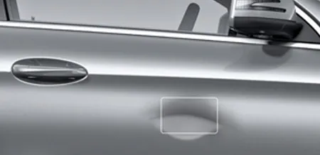 A close-up of a dent on the exterior of a door.