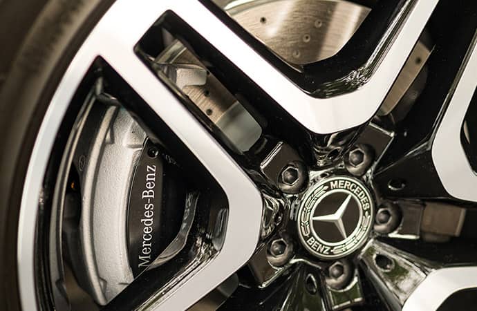 A close-up of the Mercedes-Benz logo at the center of a chrome rim. 