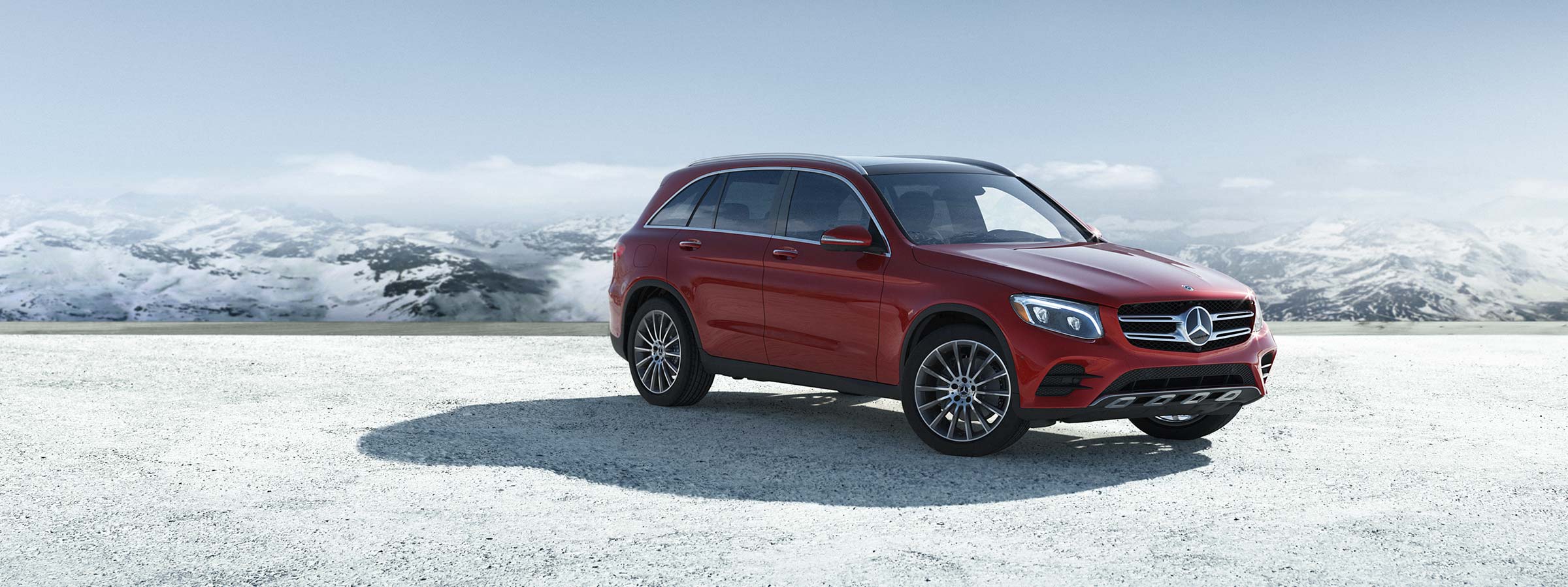 A red GLC SUV parked on a snowy landscape