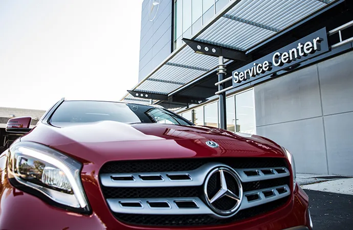 A red Mercedes-Benz parked in front of a Service Center