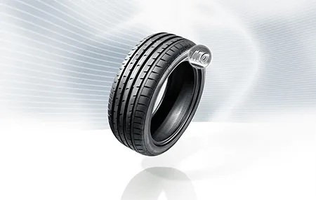 An MO Tire floats on its axis over a white and gray background.